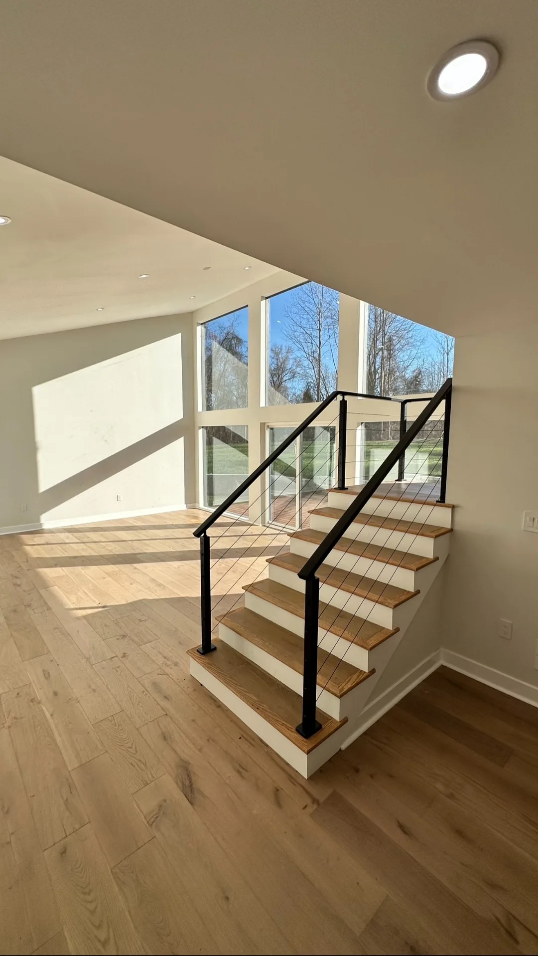 Cable-rail stair from below, new white oak treads