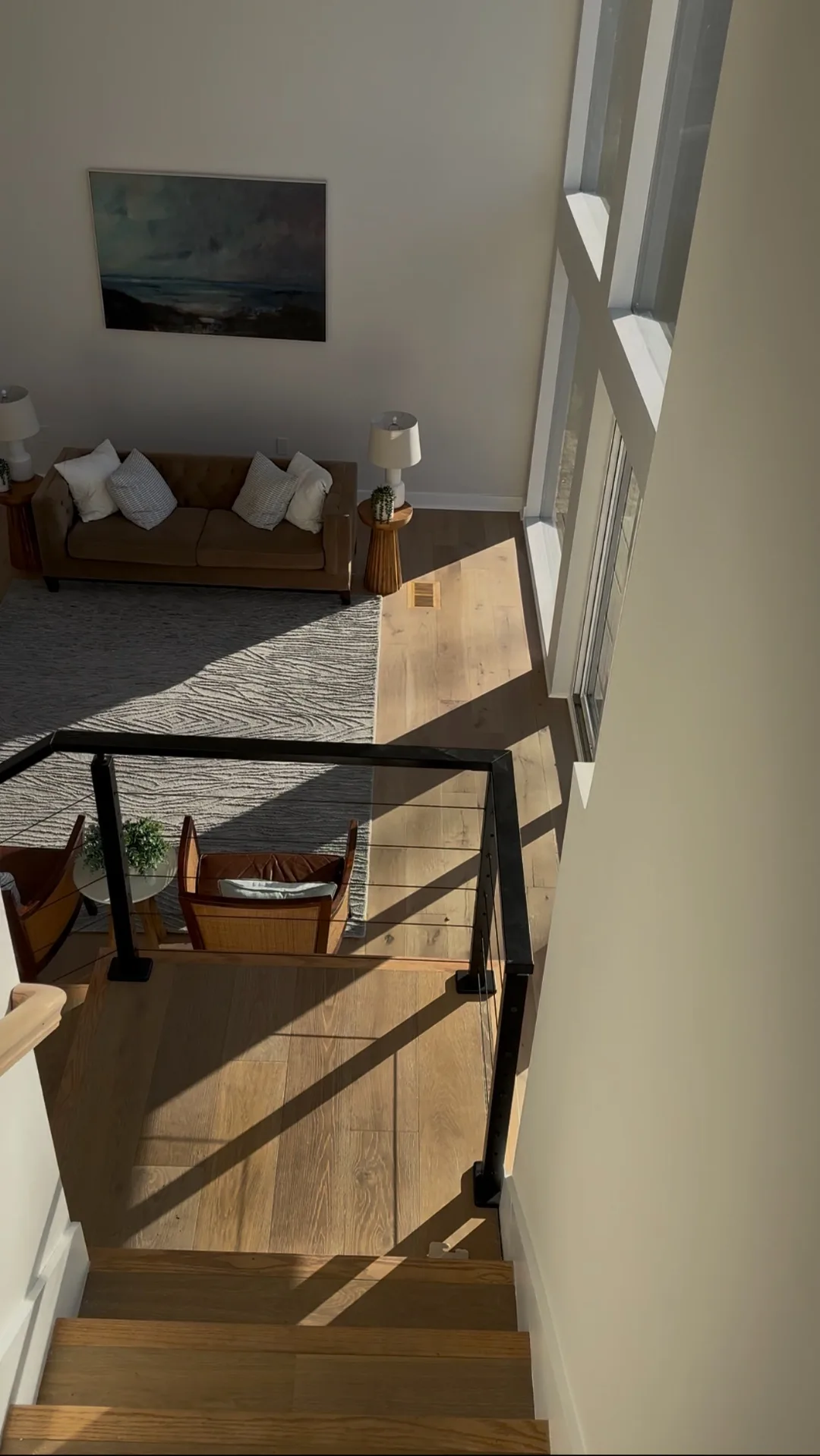 View from stair landing into living area with leather sofa